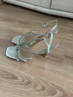 Elegante silberfarbene High Heels mit funkelnden Strassriemen